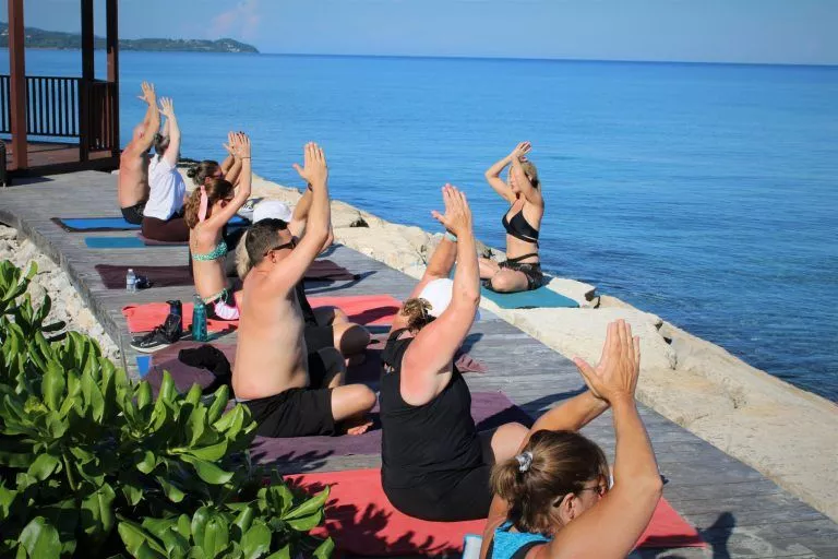 A group of people doing yoga on the beach.