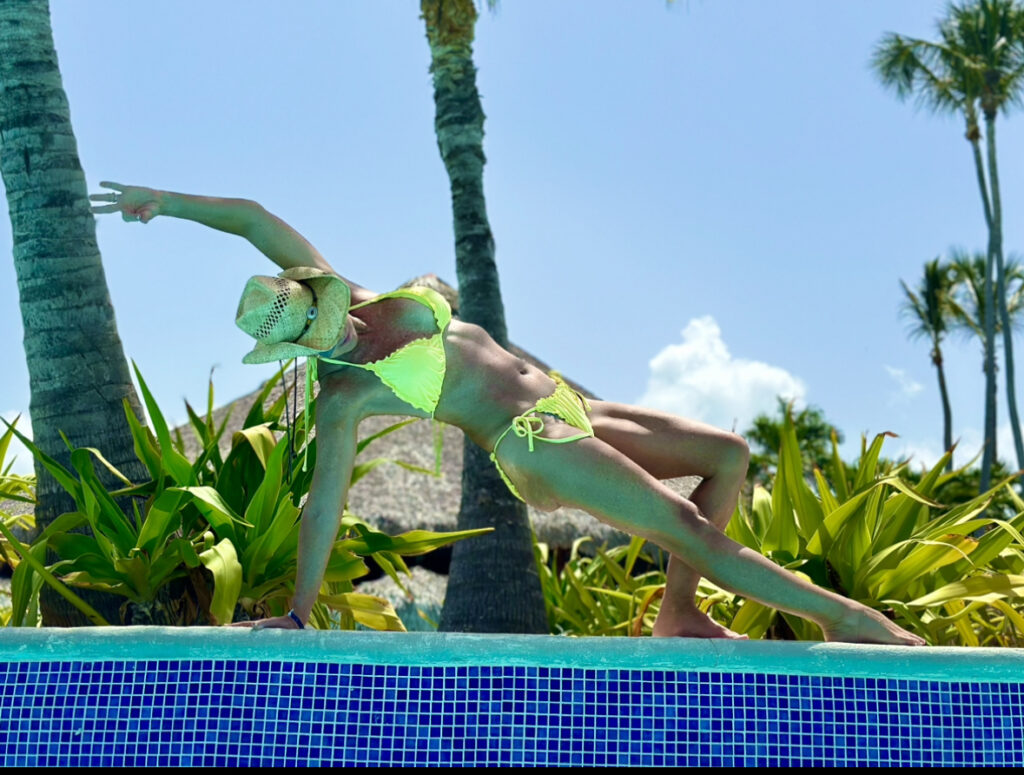 A woman in green bikini diving into the pool.