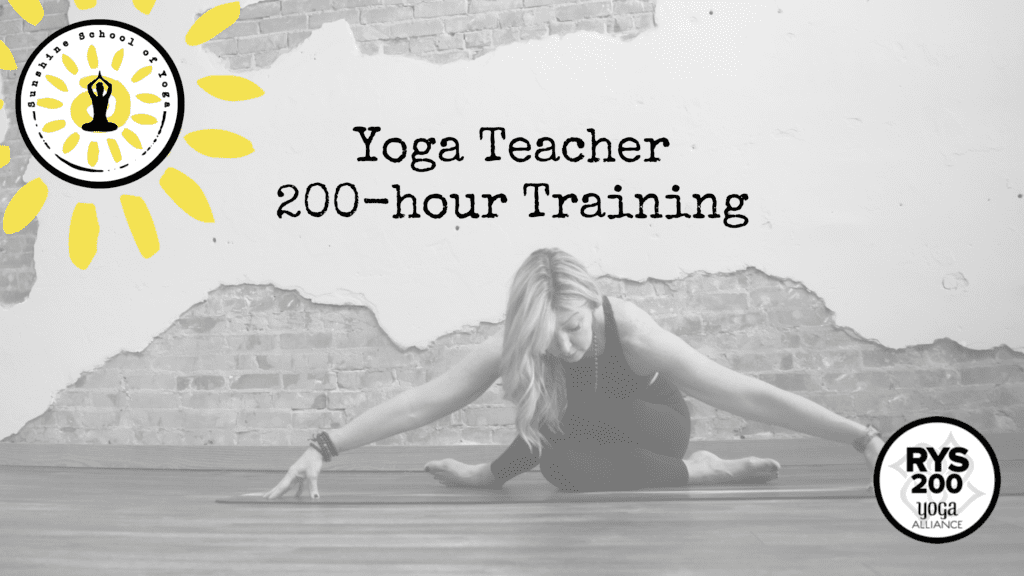 A woman sitting on the ground in a yoga class.