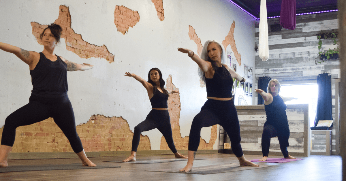 Two women are doing yoga in a gym.