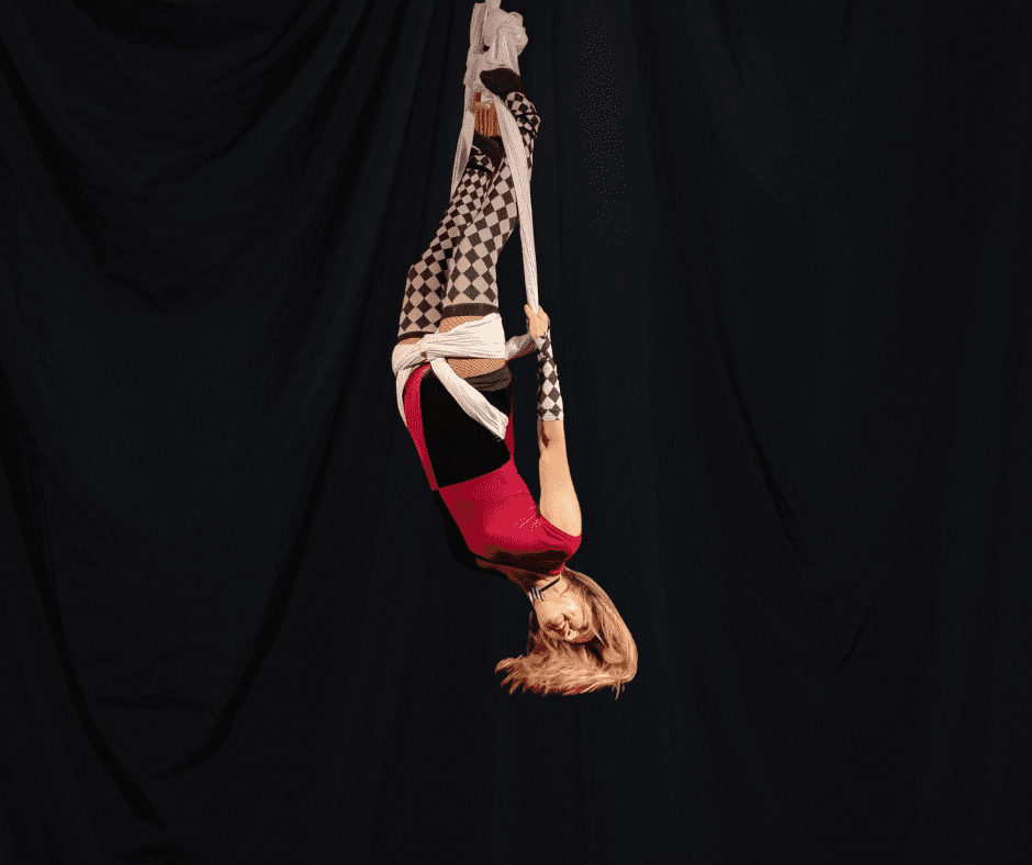 A woman hanging upside down on a rope.